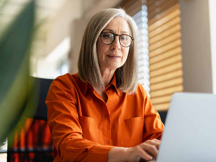 A person on a laptop who wants to enroll in Medicare while still working.
