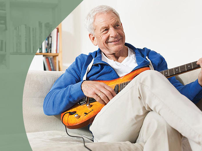 A Medicare eligible person playing the guitar