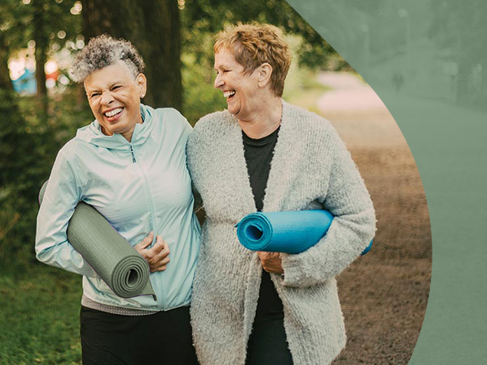 Two people eligible for Medicare Advantage PPO plans walking and holding yoga mats.