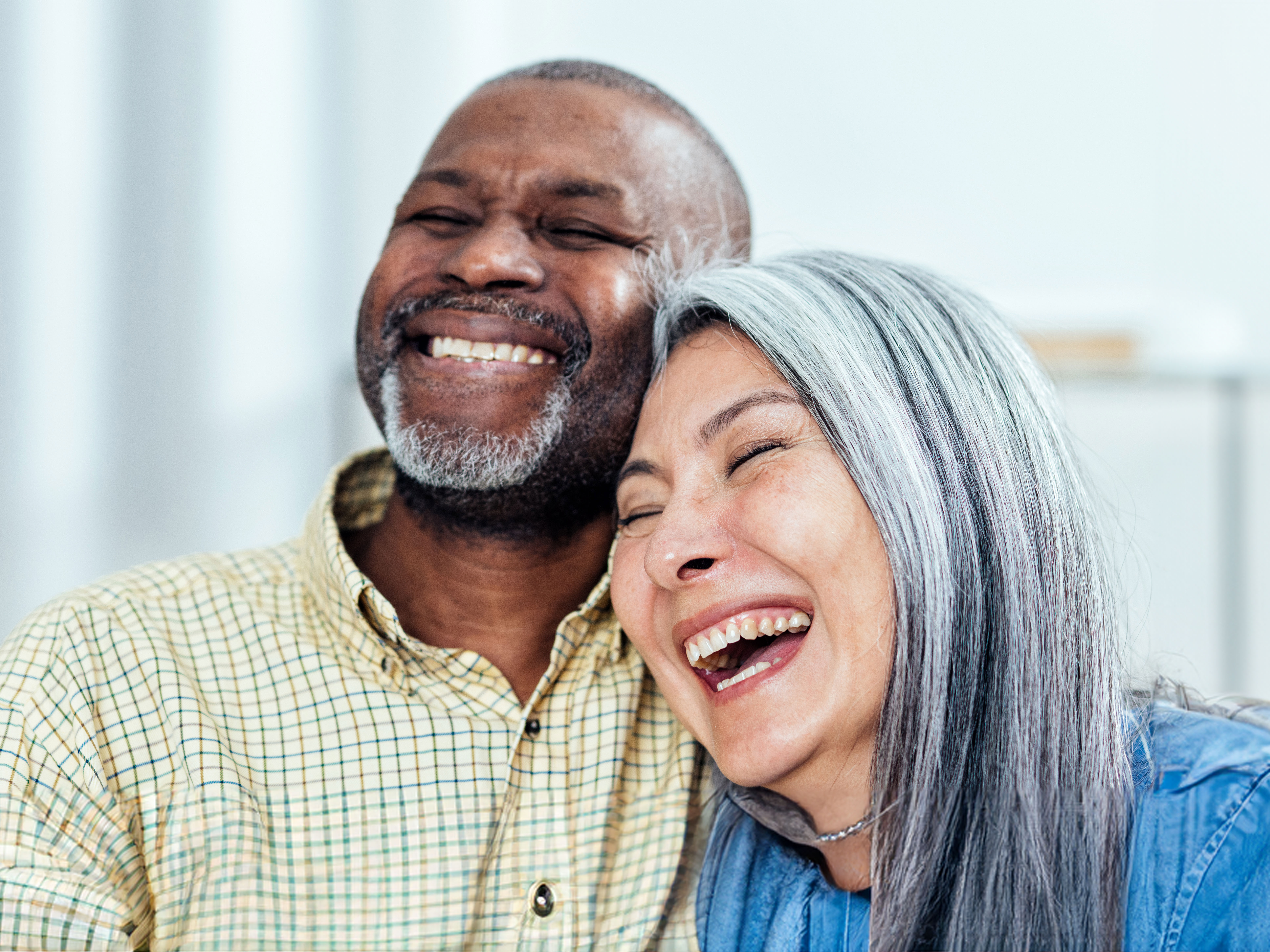Two people eligible for Medicare SNP plans smiling together.