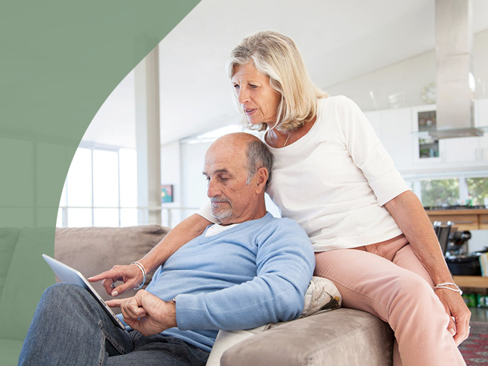 Two people looking at a laptop and researching Aetna Medicare HMO-POS plans.