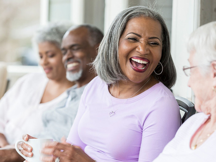 A person who is eligible for a Medicare Advantage HMO plan talking in a group.