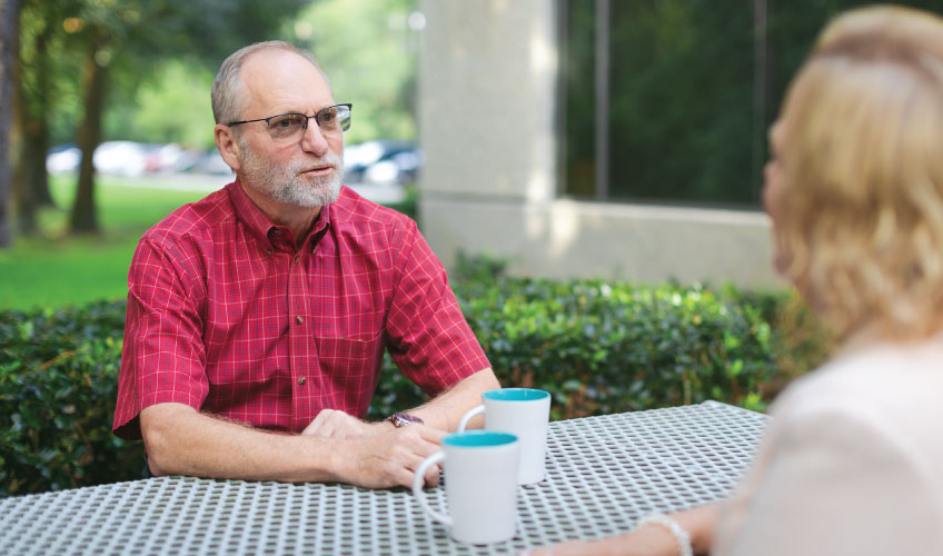 two older individuals discussing Medicare information